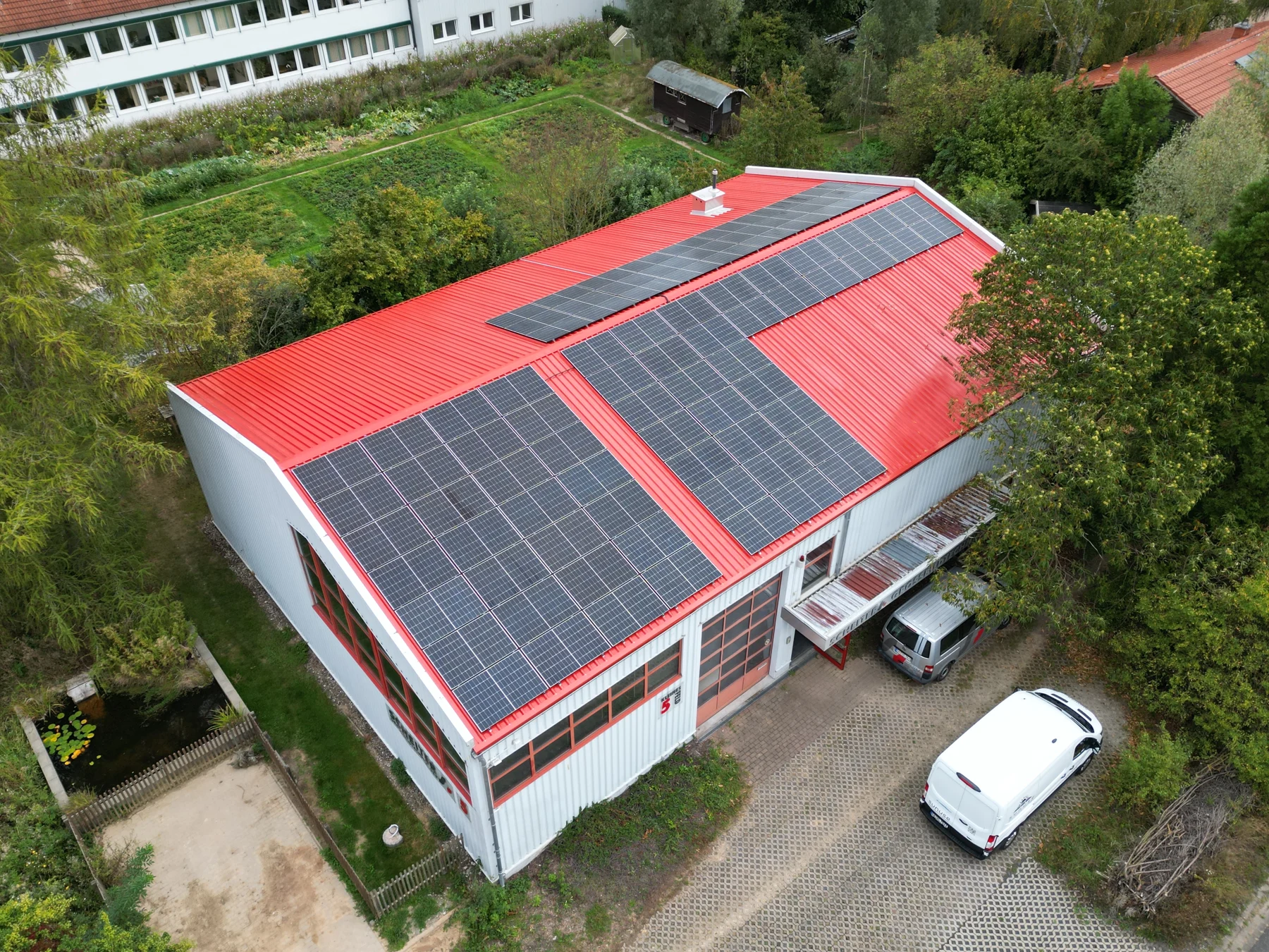 Photovoltaikanlage auf dem roten Dach eines Firmengebäudes